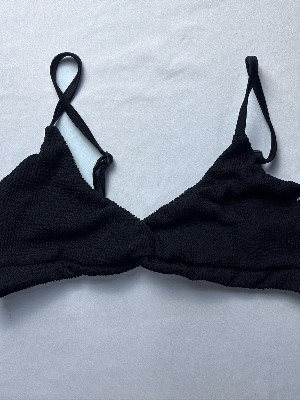 Good American Always Fits Twist Bikini Top in black.